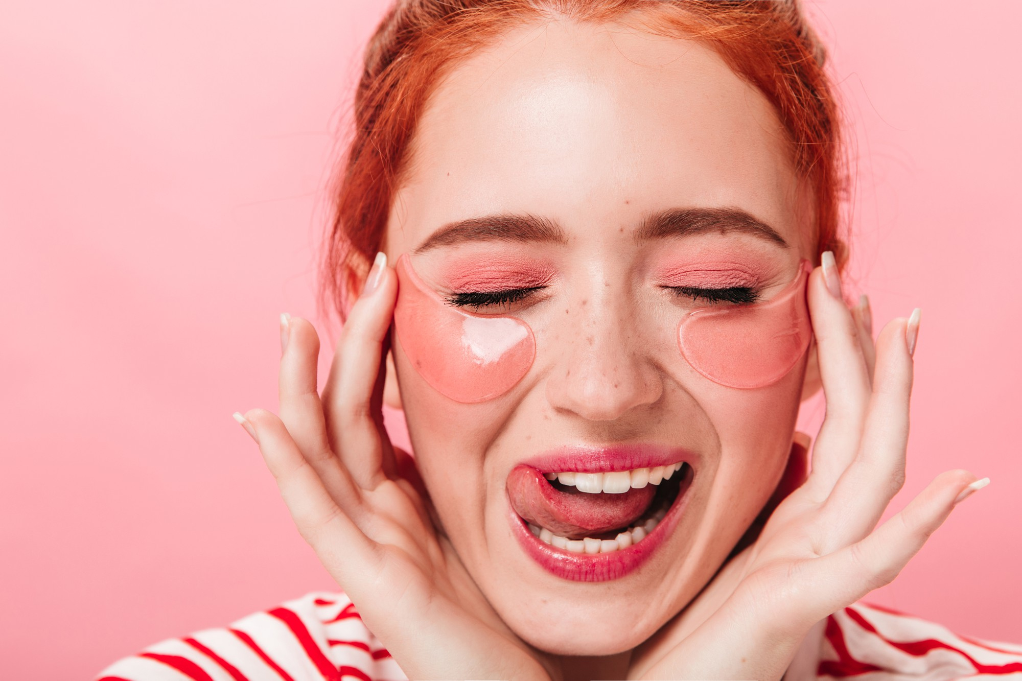 fille faisant des grimaces droles sur fond rose