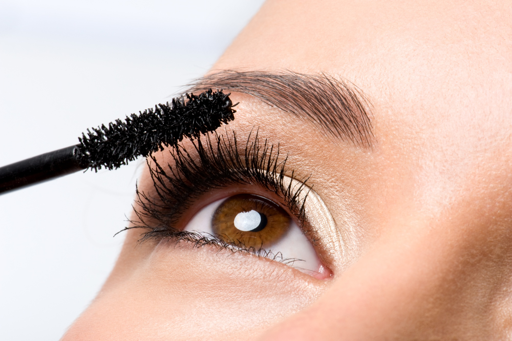 Femme qui applique du mascara